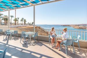 沙姆沙伊赫Albatros Sharm Resort - By Pickalbatros的两个女人坐在一个海景阳台上