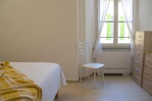 坎诺比奥Casa Dolly - WelcHome的卧室配有床、椅子和窗户。