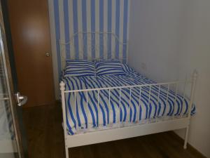 萨拉戈萨JUNTO AL PILAR的一张带蓝色和白色条纹毯子的床