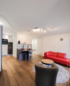 坎佩尔T3 au centre ville avec balcon, parking gratuit的一间带红色沙发的客厅和一间厨房