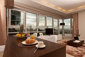 华沙铂金公寓的客厅配有餐桌和食物