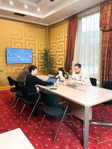 敖德萨Ark Palace Hotel & SPA的一群人坐在桌子上,手提电脑