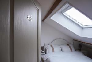 迈松阿尔福La Maison Charentonneau的一间卧室设有一张床和一个窗口