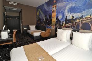 阿姆斯特丹Hotel Van Gogh的酒店客房设有两张床,墙上挂有绘画作品