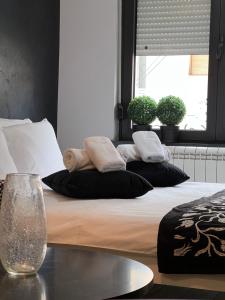 贝尔格莱德Apartment Story,Kajmakcalanska Beograd的一张带黑白枕头的床和窗户