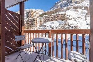 瓦勒迪泽尔Résidence Le Val d'Illaz - Val-d’Isère的一个带两把椅子的阳台,一个雪覆盖的山
