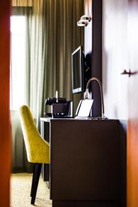 卡尔斯鲁厄德布劳尔雷特酒店的客房设有一张桌子、一把椅子和一台电脑