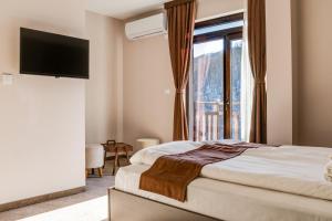 基尔科沃Family Hotel LILIUM的一间卧室设有一张床和一个大窗户