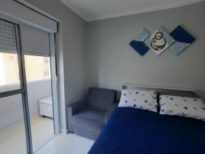 桑托斯Real Pé na Areia - José Menino/ Santos的卧室配有床、椅子和窗户。