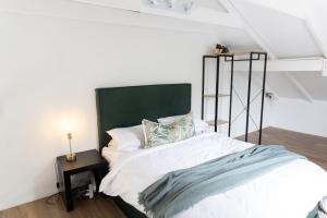 德班Peaceful Modern Home with Private Garden in Durban North的一张白色的床,在房间里设有绿色床头板