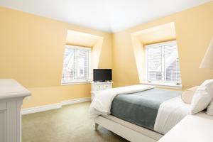 纽波特佩勒姆庭院酒店的一间卧室设有一张床和两个窗户。