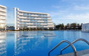阿纳帕Movenpick Resort & SPA Anapa Miracleon的大楼前的大型游泳池