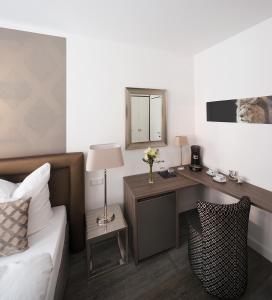 亚琛哈恩纳德酒店的一间卧室配有一张桌子、一张床和一面镜子