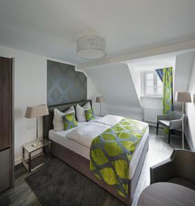 亚琛哈恩纳德酒店的一间卧室配有一张大床和一把椅子