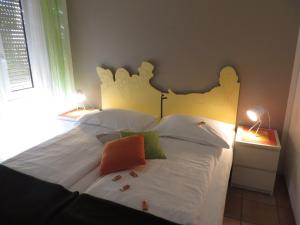 洛迦诺莫塔酒店的一间卧室配有一张带两盏灯的大型白色床。