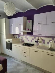 法布罗La Bomboniera di Marco的厨房配有白色橱柜和紫色墙壁