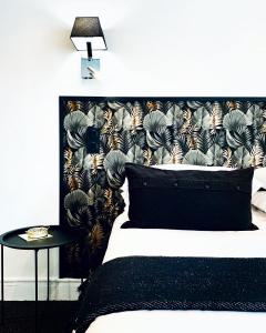 勒图凯-巴黎普拉日Hôtel Gaspard的一间卧室配有一张带黑色床头板和一张桌子的床。