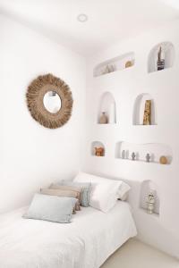 索伦托Sole Suites的卧室设有白色墙壁和一张带镜子的床