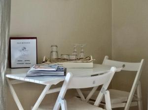 伊特博尔德BENVENUTI的一张带两把白色椅子和盒子的白色桌子