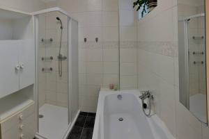 海布Příjemný řadový rodinný dům se zahradou的白色的浴室设有浴缸和淋浴。