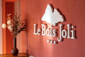 贝尔内Hotel Le Bois Joli的挂有读公车账单标志的墙