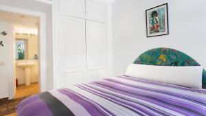雅弗郎其Apartment Sabin - Llafranc的白色客房,配有一张带紫色毯子的床