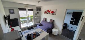卡布尔Résidence Front de mer Cabourg - Accès direct plage的客厅配有紫色沙发和桌子
