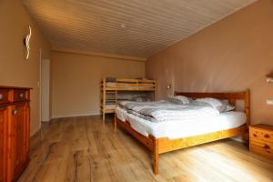 WernesgrünFerienwohnung Steinberg mit Sauna的一间卧室配有一张床,铺有木地板