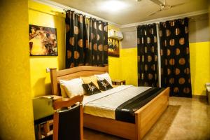库马西Homey Lodge的黄色间内一间卧室,配有一张床
