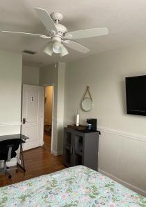 迈阿密Casa Miami 3的一间卧室配有吊扇、一张床和一张书桌