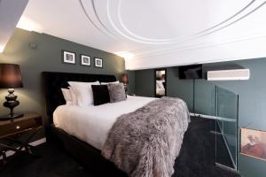 布伦海姆Hotel D'urville Blenheim的一间卧室配有一张大床和毛绒毯子