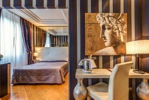 罗马亚特兰特星级酒店的卧室配有一张床和一张桌子,墙上有一张桌子