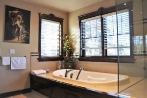 卡尔加里西山河旅馆的带浴缸和窗户的大浴室