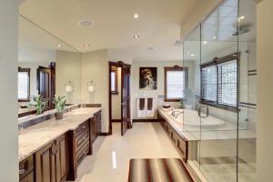 卡尔加里西山河旅馆的浴室配有2个盥洗盆、浴缸和淋浴。
