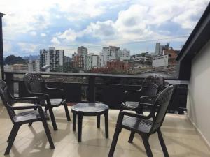 马尼萨莱斯Casa Azul的阳台配有桌椅,享有城市美景。
