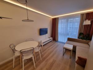 什切青Apartamenty 21 Śląska的客厅配有桌子和沙发