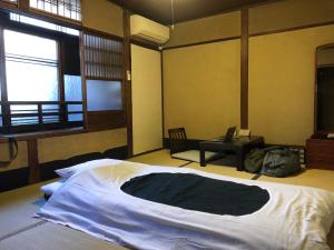 京都京都五条旅舍的一间卧室配有一张大床和一张书桌