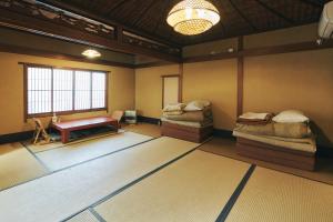 京都京都五条旅舍的一间设有两张床和一张桌子的房间