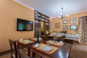 布拉恰诺拉吉斯孟达农家乐的用餐室配有长桌和平面电视。