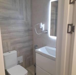 乌拉尔斯克Kaspi Hotel的浴室配有白色卫生间和盥洗盆。