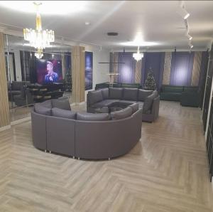 乌拉尔斯克Kaspi Hotel的带沙发和电视的大型客厅