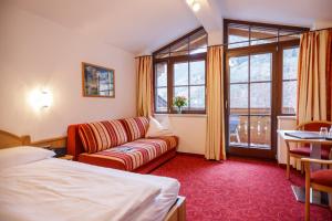 大格洛克纳山道旁富施Feriendorf Ponyhof的酒店客房设有床、沙发和窗户。