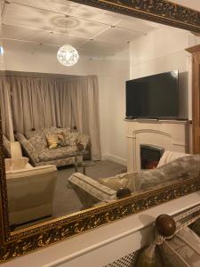 南安普敦Citretum Angulus的客厅配有镜子、沙发和电视