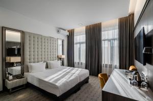 维尔纽斯会议酒店的酒店客房配有一张床、一张书桌和一台电视。