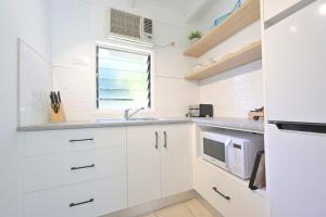 耐莉湾曼德勒阿马鲁度假村的厨房配有白色橱柜、水槽和窗户。