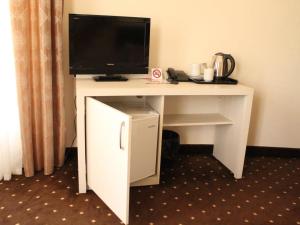 杰尔穆克杰尔穆克维罗纳度假酒店的一张白色的桌子,上面有一台电视