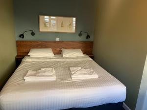 多切斯特老船旅馆的一间卧室配有一张大床和毛巾