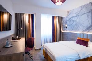 伯布林根伯勒​​尔酒店的酒店客房设有一张床、一张书桌和窗户。