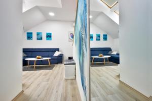 KriževciFlorek & Florica Apartment的客厅设有蓝色的沙发和冲浪板