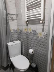 库塔伊西AnSeZa的浴室设有白色卫生间,墙上挂有鲜花。